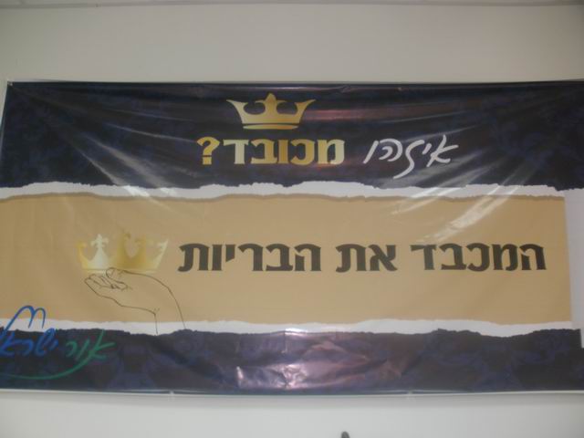 זה שלט שהיה תלוי באולם אך רק אדם אחד שם לב אליו אולי בגלל הגובה שלו קותי אהרון.